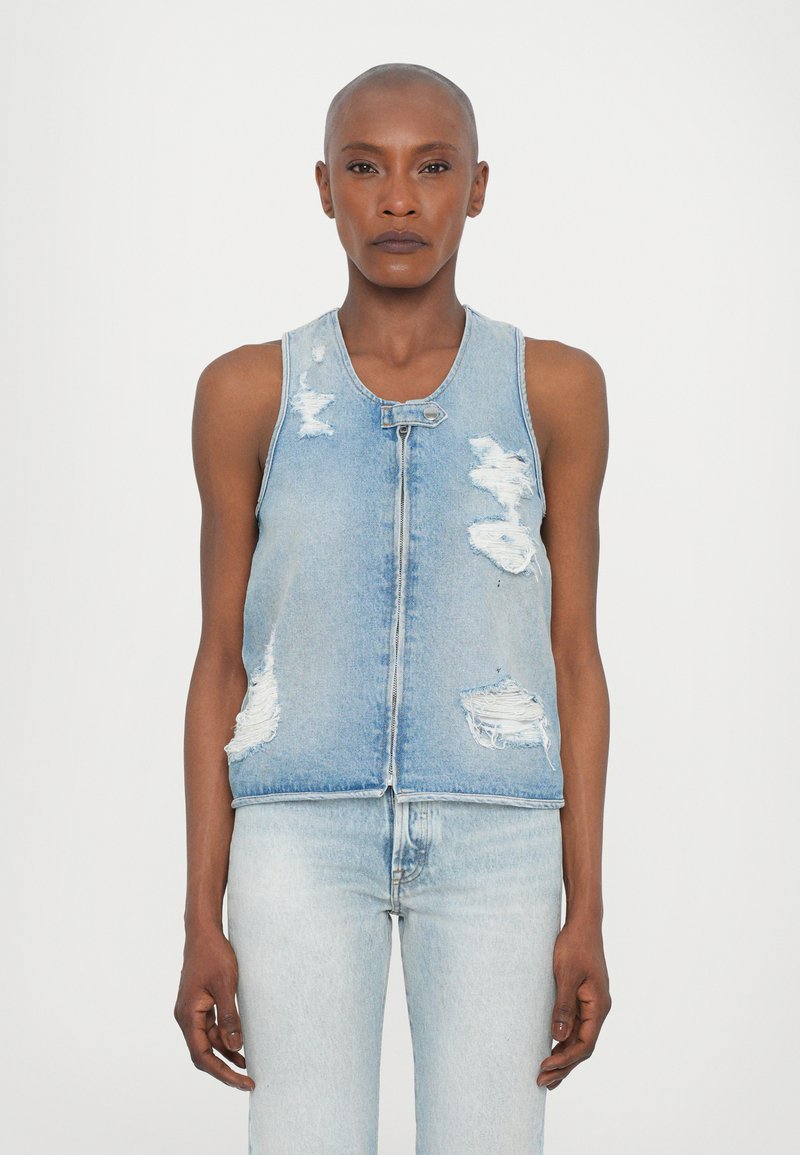 Heled sinine denimpusa, millel on kulumisjälgedega detailid. Omab esimest tõmbluku ja varrukateta disaini, koos sobivate heledate siniste teksadega.