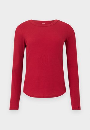 Haut rouge en maille côtelée à manches longues, col rond, ourlet incurvé, silhouette ajustée et étiquette GAP à l'intérieur du col.
