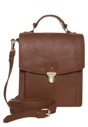 Ruskea nahkainen olkalaukku, jossa on yläkahva, etuläppä, kultainen lukko ja säädettävä olkahihna valkoista taustaa vasten.