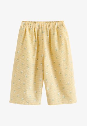 Žlté kockované šortky s malými bielymi kvetinovými potlačami a elastickým pásom.