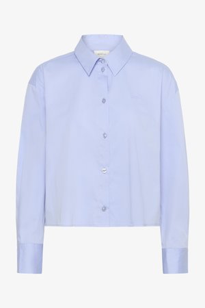 Šviesiai mėlyna trumpa mygtukinė marškinė su apykakle, ilgomis rankovėmis ir skaidriais mygtukais. Subtilus logotipo detalė krūtinėje.