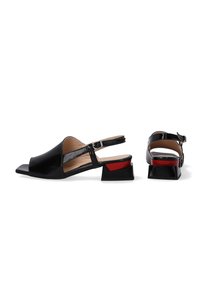 Zwarte slingback sandalen met een glanzende afwerking, voorzien van een vierkante neus, blokhak met rode accenten en een verstelbare enkelband.