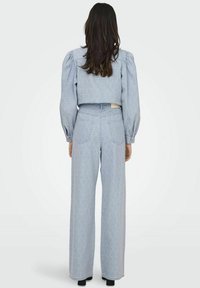 Lichtblauw cropped top met pofmouwen en bijpassende hoog-getailleerde wijde broek, met een subtiele textuur en een patroonontwerp.