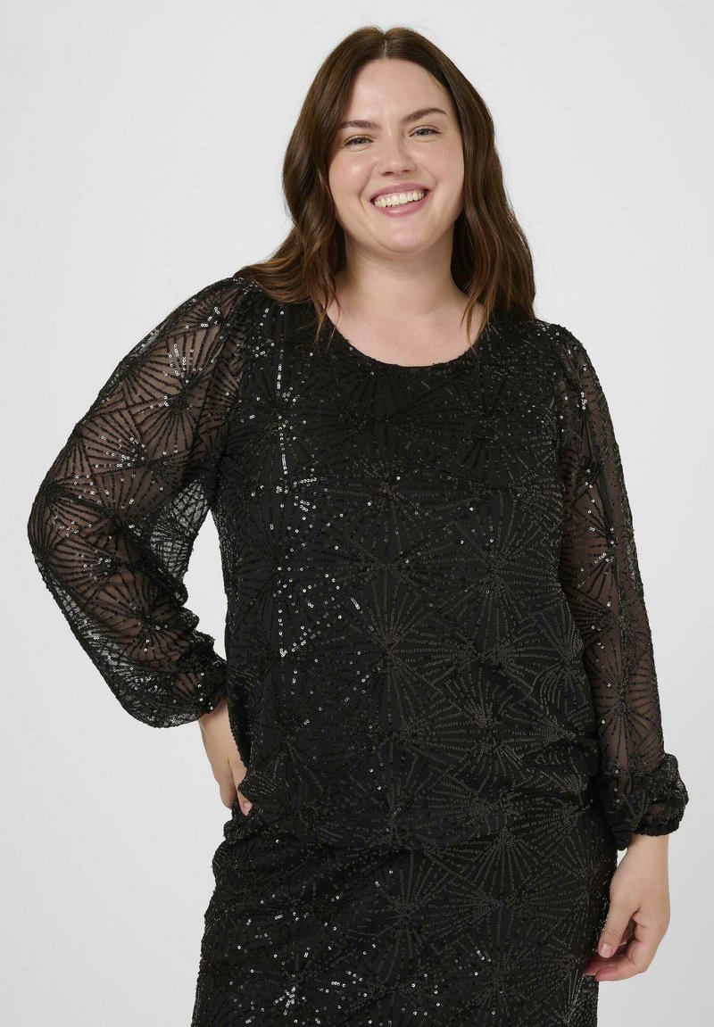 Haut noir en sequins avec de longues manches transparentes, présentant un motif géométrique d'étoiles et de lignes, tissu texturé, encolure ronde et coupe décontractée.