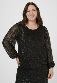 Black sequined top with long sheer sleeves, featuring a geometric pattern of stars and lines, textured fabric, round neckline, and relaxed fit.