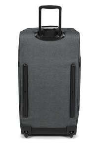 Maleta de tela gris con carcasa rígida, asa retráctil, cuatro ruedas y detalles en negro. Presenta una textura exterior suave y un diseño elegante.
