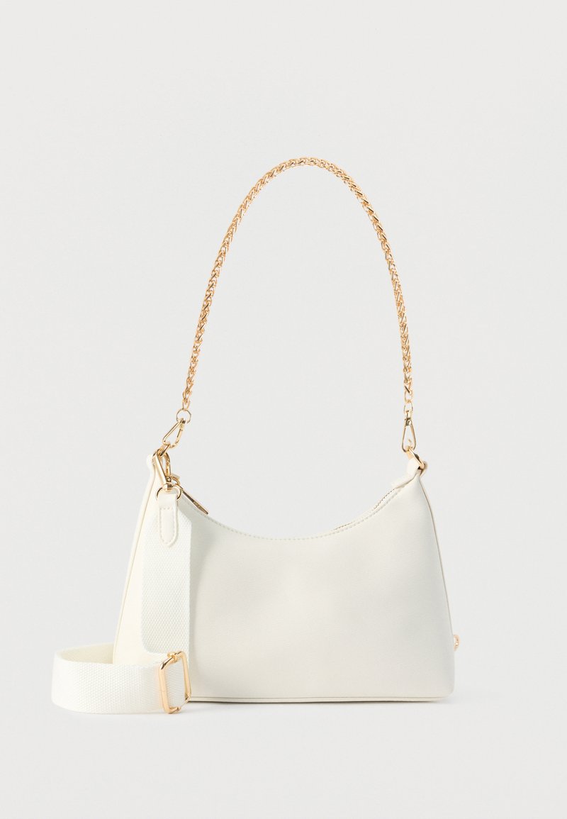 Sac à main rectangulaire blanc avec poignée supérieure à chaîne dorée et bandoulière détachable en tissu blanc sur fond blanc.