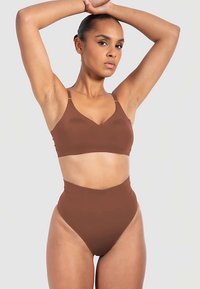 Bruine bralette en hoog uitgesneden bikini-set gemaakt van gladde stof, met minimale naden en verstelbare bandjes voor een comfortabele pasvorm.