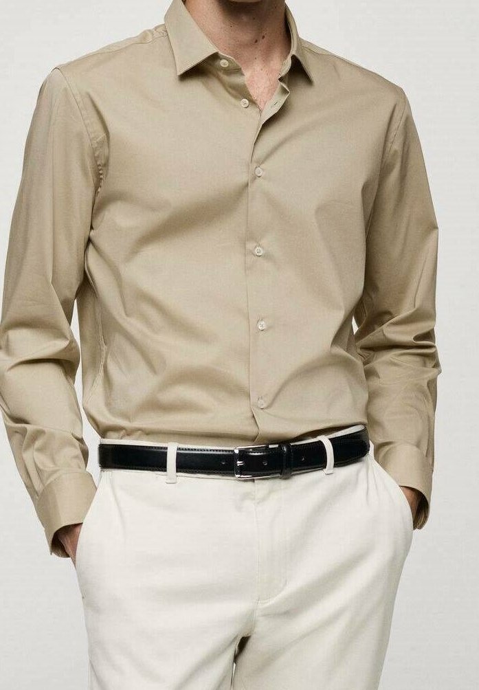 Camicia da uomo color khaki con colletto a punta, maniche lunghe e chiusura con bottoni; abbinata a pantaloni bianchi e una cintura nera. Texture liscia.