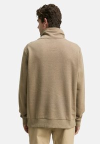 Bruine, gestructureerde fleece sweatshirt met een hoge kraag, drop shoulders en ribgebreide manchetten. De zoom ligt op heuphoogte. Achteraanzicht weergegeven.