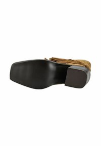 Braune Wildleder-Ankle-Boots mit Fransenverzierung, die eine gerippte schwarze Gummisohle und einen Blockabsatz vor einem weißen Hintergrund zeigen.