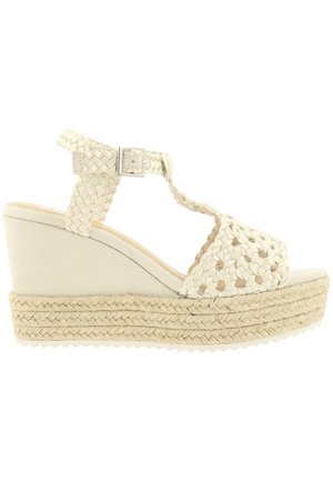 Beige kile sandal med fletbundet sål, vævet T-rem overfoden og ankelrem med sølvspænde.