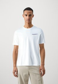 T-shirt bianco a maniche corte in cotone con scollatura rotonda, caratterizzato da un logo colorato "Diesel Industry" sul lato sinistro del petto.