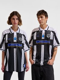 Zwei Models tragen schwarz-weiß gestreifte SWARM Internationals Sporttrikots mit Logos und stehen vor einem einfarbigen hellen Hintergrund.