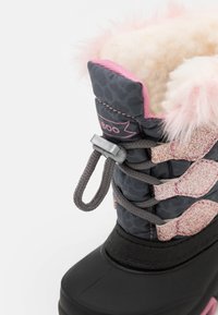 Botte imperméable noire avec un motif léopard gris, bord en fourrure rose et accents pailletés. Dotée d'un système de lacets et de fermeture à toggle pour un ajustement sécurisé.