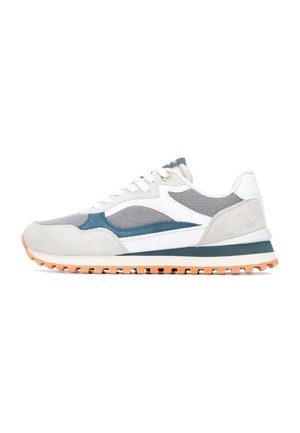 Zapatillas grises y blancas con paneles de malla, acentos de ante y una suela de goma texturizada en naranja y negro. Cuenta con un cuello acolchado.