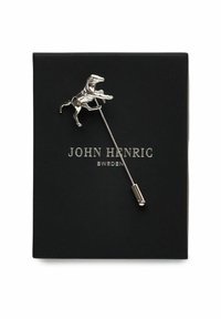 Silverfärgad hästformad slipsnål på en lång metallpinne, uppvisad i en svart låda med varumärket "John Henric" präglat i silver.