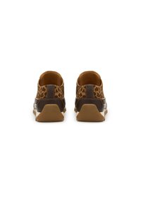 Un paio di scarpe slip-on marroni con stampa leopardata viste da dietro, con suole in gomma su uno sfondo bianco.