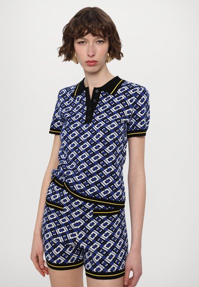 Ensemble comprenant un polo à manches courtes à motifs bleus et un short, mettant en avant des motifs géométriques, avec un col noir et des accents, fabriqué dans un tissu tricoté texturé.