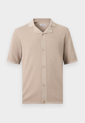 Chemise en maille beige à manches courtes avec motif texturé, fermeture boutonnée sur le devant et col ouvert.