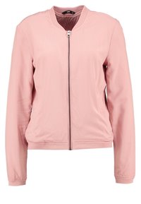 Różowa bombka wykonana z lekkiego materiału; posiada zamek błyskawiczny z przodu, ściągacze przy mankietach i u dołu oraz luźny krój. Gładka faktura, bez wzorów.