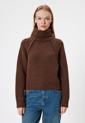 Brown knitted sweater with a high ribbed collar, raglan sleeves, and a boxy fit. Features a textured design and ribbed hem.