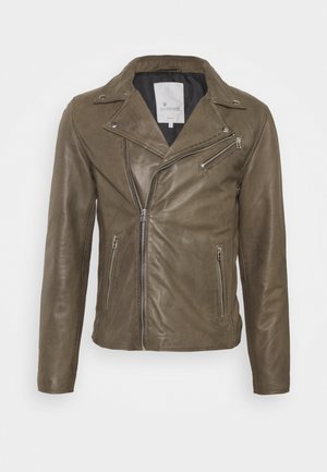 Veste de motard en cuir marron avec fermeture éclair asymétrique à l'avant, poches zippées, larges revers et détails à boutons-pression métalliques sur le col et les épaules.