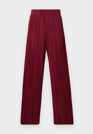 Pantalons larges plissés bordeaux avec une taille élastique. Le tissu texturé présente des rayures verticales. Coupe droite jusqu'à l'ourlet.