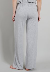 Lichtgrijze, ruime loungebroek van zacht, rekbaar materiaal met een elastische tailleband, met rechte pijpen en een gladde textuur.