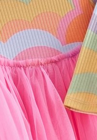 Wielokolorowa sukienka z ribbowanym korpusem w pastelowych odcieniach, różowa spódnica z tiulu i miękka tekstura. Falbaniasty dół i szerokie rękawy w paski.