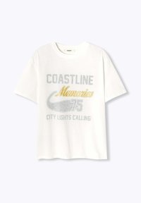 T-shirt en coton blanc avec un graphique "COASTLINE Memories" en argent et or, col rond, manches courtes et coupe décontractée.
