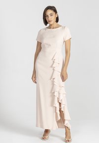 Różowa sukienka maxi z krótkimi rękawami, z ukośnym detalem falbanek po boku i skromnym rozcięciem u dołu. Gładka faktura.