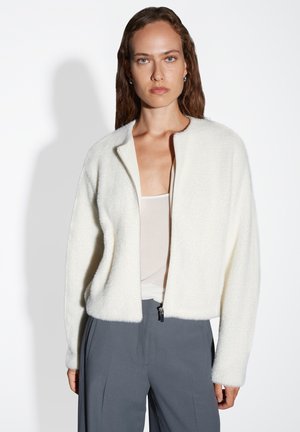 Witte fleece jack met een rits aan de voorkant, ronde halslijn en een cropped fit. Heeft lange mouwen en een ge textureerde, zachte oppervlakte.