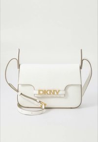 Λευκή δερμάτινη τσάντα χιαστί με χρυσό λογότυπο "DKNY", κομψό σχέδιο, δομημένο σχήμα και αποσπώμενο ιμάντα σε ουδέτερο χρώμα.