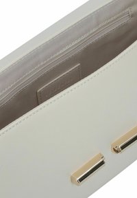 Borsa a mano in pelle bianca con una texture liscia, dotata di un interno beige e dettagli in hardware dorato. Include una tasca con zip per una conservazione sicura.