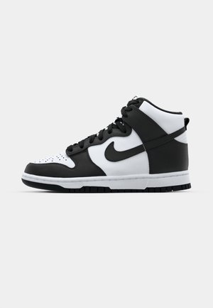 Baskets montantes noir et blanc avec tige en cuir, boîte à orteils perforée, logo swoosh proéminent et semelle en caoutchouc texturée.