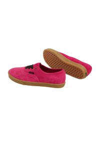 Baskets en daim rose avec lacets noirs, bout arrondi et semelle en caoutchouc marron dotée d'une semelle antidérapante à motif. Tige légèrement texturée.