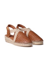 Sandales en cuir tressé marron avec des sangles élastiques beiges, avec une semelle en jute style espadrille et un design à dos découpé, texture lisse.