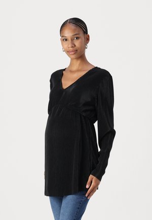Black ribbed maternity top with long sleeves, V-neckline, and cinched waist, featuring a soft, textured fabric and a relaxed fit.