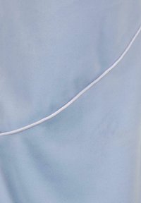Tessuto azzurro chiaro con una morbida texture, caratterizzato da un dettaglio di piping bianco curvo. Superficie liscia con una leggera lucentezza.