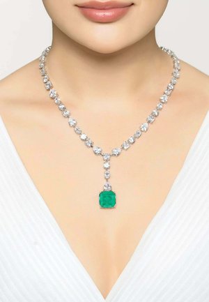 Silver necklace featuring clear gemstones and a central square green stone, showcasing a smooth texture and elegant design.