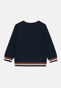 Pull bleu marine avec un col rond et des manches longues. Présente des poignets et un ourlet rayés orange, blanc et bleu marine. Texture en maille lisse.