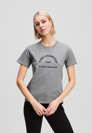 Camiseta de algodón gris con cuello redondo, mangas cortas y texto negro: "KARL LAGERFELD PARIS 21 RUE ST-GUILLAUME."