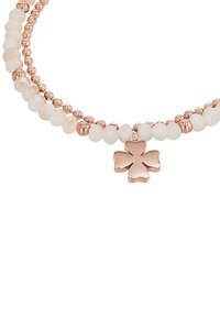 Bracciale con perline rosa oro e bianche, con un piccolo charm a trifoglio rosa oro appeso al centro.