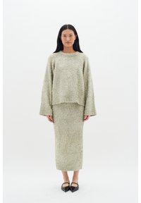 Ljusgrön, fluffig stickad tröja med drop shoulders, kombinerad med en matchande stickad midiklänning. Båda har en mjuk textur och avslappnad passform.