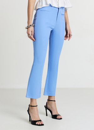 Light blue tailored pants with a smooth texture, slim fit, and side pockets, paired with black high-heeled sandals.