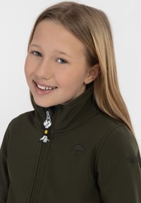 Giacca verde scuro con colletto alto, chiusura con zip e logo dell'ombrello ricamato. Presenta un cursore della zip decorativo con accenti in tessuto.