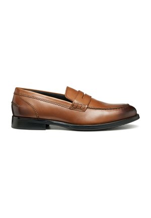 Mocasines de cuero marrón con detalle de costura, una correa ancha en el empeine y una punta ligeramente curvada. Suela de goma negra para agarre.