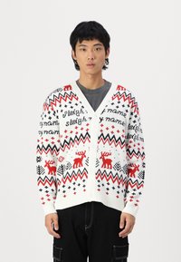 Rød, hvid og sort strikket cardigan med rensdyr, geometriske mønstre og knaplukning. V-hals design og ribbede manchetter.