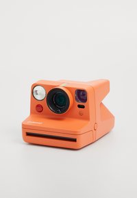 Élénk narancssárga Polaroid azonnali fényképezőgép, kerek objektívekkel, vakuval és színes csíkkal díszítve. Kompakt, téglalap alakú kialakítás filmmagazin helyével.